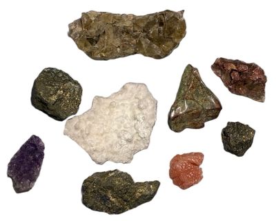 many different colored rocks on a white surface