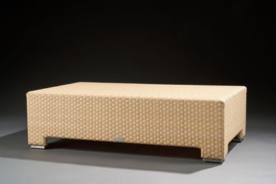 an upholstered bench made of woven fabric on a black background