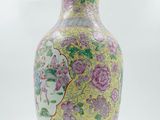 a yellow vase with pink flowers on it on a white background