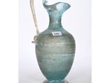 a blue vase with a white handle sitting on a table
