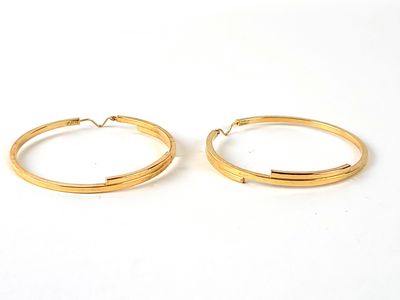 deux paires de boucles d'oreilles en or sur fond blanc