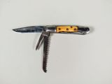un petit couteau au manche jaune posé sur une surface blanche