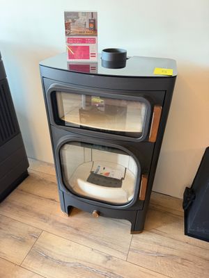 un petit poêle noir posé à côté d'une valise noire
