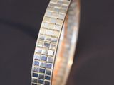 a close up of a silver ring on a black surface