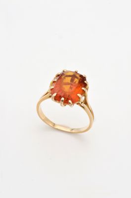 une bague en or sertie d'une pierre orange entourée d'un diamant