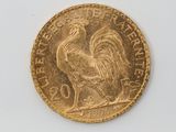 a gold coin with a rooster on it on a white surface