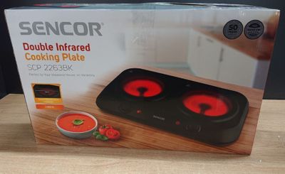 boxed picture of a black and red double infrared cooking plate on a table