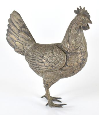un poulet argenté posé sur une surface blanche