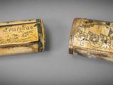 two wooden boxes with carvings on them sitting next to each other