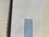 une enveloppe blanche avec une fenêtre, posée sur une table en bois