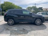 the black jeep is parked in a parking lot next to a silver car