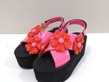 une paire de sandales roses et noires ornées de fleurs