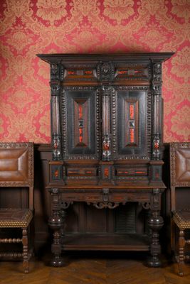 deux chaises et une armoire dans une pièce au papier peint rouge