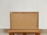 a box sitting on top of an easel on the floor