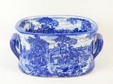a blue and white bowl with handles on a white surface