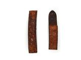 two pieces of brown leather are laying next to each other on a white surface