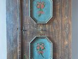 a wall mounted clock with three flowers painted on it