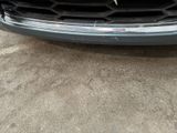 the front end of a car with a grille and a number plate on it
