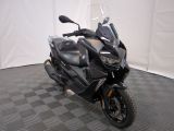 une photo d'une moto noire garée sur un sol à damier