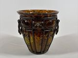a brown vase that is sitting on a white surface