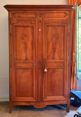 a large wooden armoire in the corner of a room
