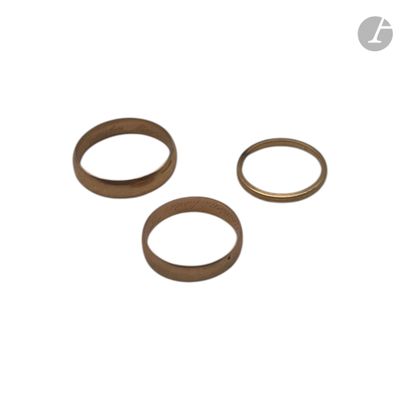 un ensemble de trois anneaux en laiton sur fond blanc
