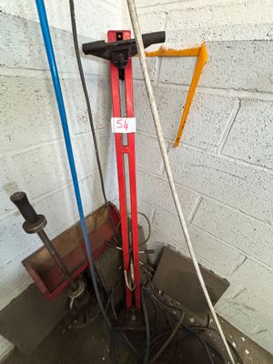 a picture of a red and blue hand pump in a garage