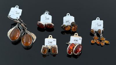 plusieurs bijoux posés sur un fond noir, accompagnés d'étiquettes de prix