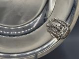 a silver plate with a lion head on it