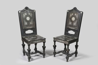 deux chaises assises l'une à côté de l'autre sur une surface blanche