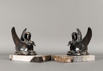 une paire de sculptures d'oiseaux en noir et blanc sur des socles en marbre