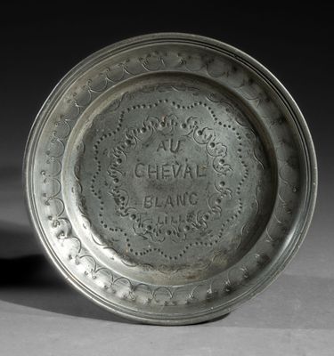 an old silver plate with a decorative design on it