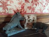 deux figurines d'animaux posées sur une table devant un papier peint