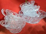 deux plats en verre transparent posés sur une nappe rouge, sur fond rouge