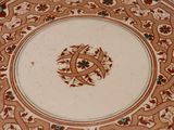 a brown and white plate with a design on it