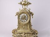 une horloge en or posée sur une surface blanche