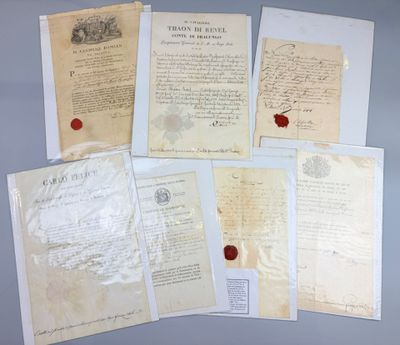 several old papers and a wax seal sitting on top of a table