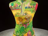 a mannequin on a table with a painting on it