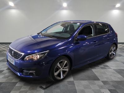 une voiture bleue garée dans un garage au sol en damier