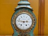 a clock that is sitting on a table in front of a wall