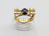 an image of a gold ring with a sapphire stone and diamonds