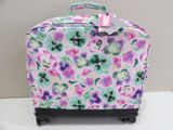 a pink suitcase with flowers on it sitting on a table