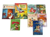 several children ' s books are lined up on a white surface