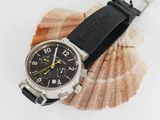 a watch sitting on top of a shell on a white surface