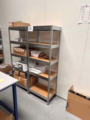une pièce avec beaucoup d'étagères et de cartons par terre