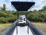 a black and white boat sitting in the grass