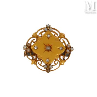 une image représentant une broche en or avec une étoile au centre