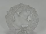 a white glass figurine sitting on top of a white table