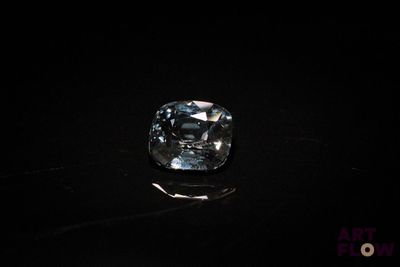 a close up of a blue diamond on a black surface