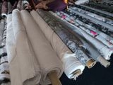 many rolls of fabric on a table in a room